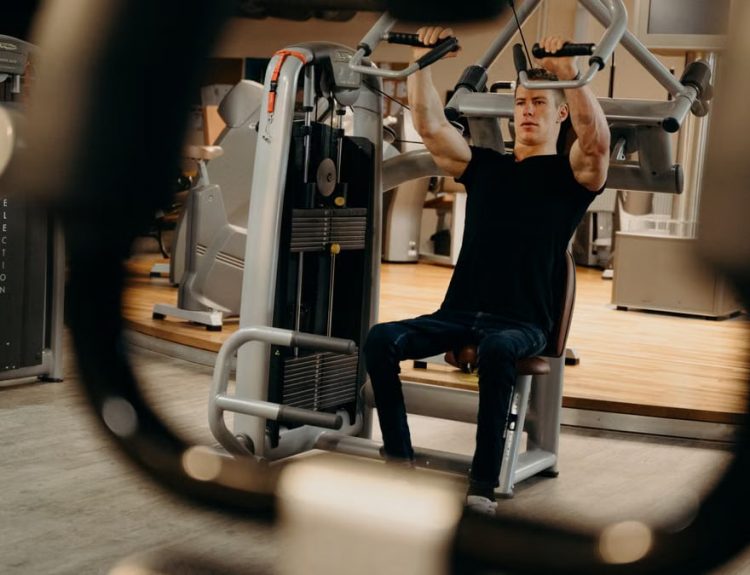 A man working out on a gym machine, focusing on upper body strength training.